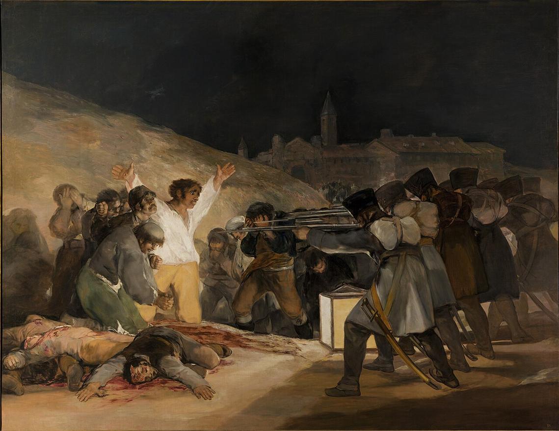 A man in a white shirt faces a row of soldiers aiming rifles at him; other figures lie beside him, lit by a lantern in the dark.