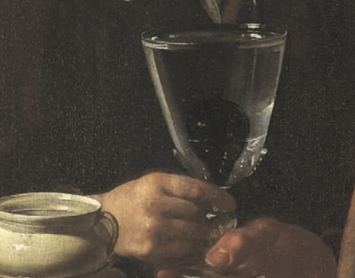 Close view of the glass of water being passed between the seller and the boy